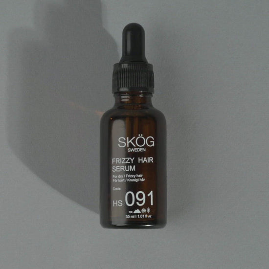 "Video showcasing SKÖG Frizzy hair serum , dark amber bottle with a  black dropper cap and an white text on the label of bottle. Gently put a drop on her hand and then applying on her hair with her fingertips. Contains avocado oil , cedarwood oil & flexseed oil