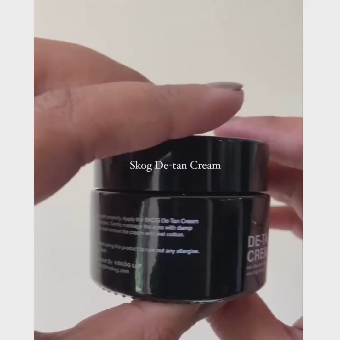 Video showcasing women applying Skog De-Tan Cream on her face with the black brush and then rubbing the texture of the cream to her face with her hands , smilling women ingredients elder flowers, lingonberries all natural ingredients tanremoval , how to remove tan 
